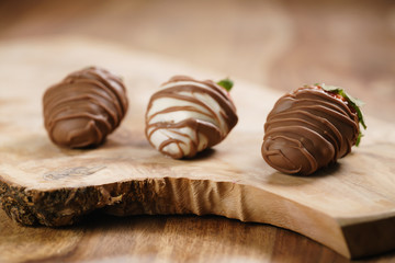 chocolate covered strawberries on wood board, shallow focus