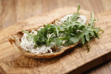 arugula on rustic bread with ricotta cheese, shallow focus