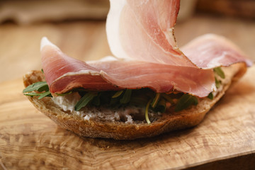 italian sandwich with speck and arugula salad, shallow focus