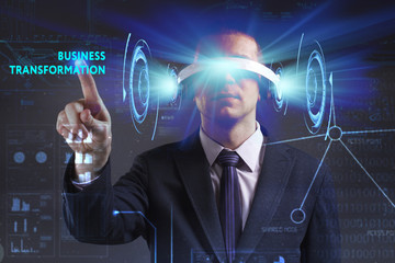 Business, Technology, Internet and network concept. Young businessman working in virtual reality glasses sees the inscription: Business transformation