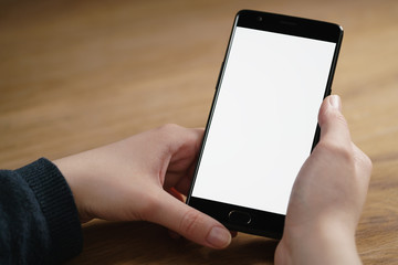 closeup shot of female teen hands with smartphone at the table, shallow focus