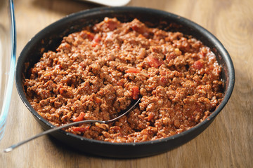 preparing lasagna process with bolognese sauce in pan, shallow focus