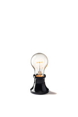 Light bulb glowing with old base on white