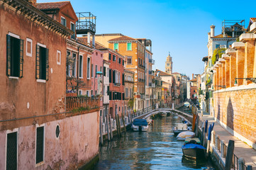 Scenic view down a quiet colorful Venetian canal in Venice, Italy - obrazy, fototapety, plakaty