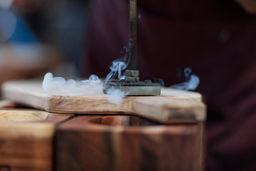 Close up of branding iron burning imprint onto chopping board in factory