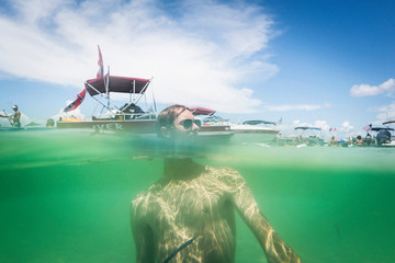 Split water level surface image of teenage boy in water, Crab Island, Emerald Coast, Gulf of Mexico, USA