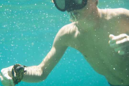 Underwater view of teenage boy with common snapping turtle, Econfina Creek, Youngstown, Florida, USA