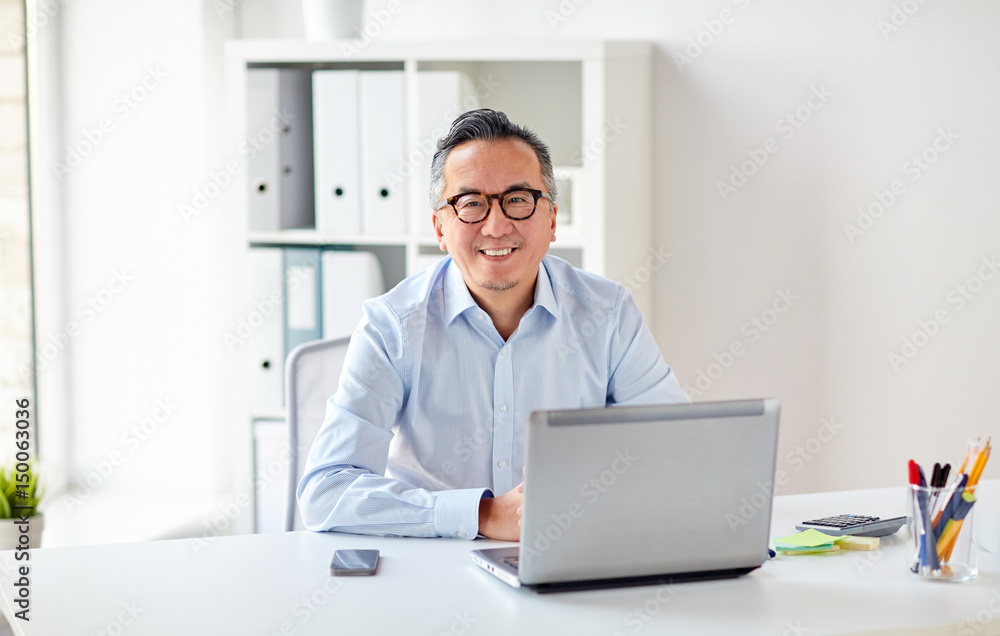 Wall mural happy businessman in eyeglasses with laptop office