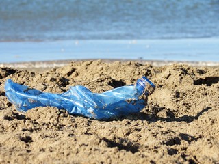 Botella de plástico aplastada en la orilla del mar / Crushed plastic bottle on the seashore