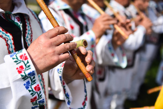 People singing at traditional wooden flutes