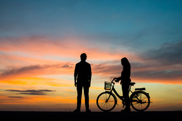Fototapeta na wymiar Silhouette couple and bycicle on sunset.
