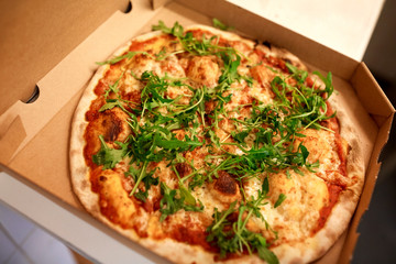 close up of pizza in box on table at pizzeria