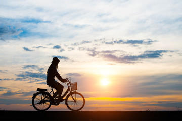 Silhouette, young women cycling with sunset.