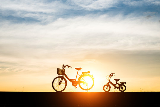 Silhouette, two bikes with sunset.