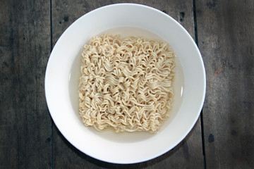 Instant noodles on a wooden table. Top view.