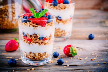 Yogurt parfait with granola,  strawberries and blueberries - obrazy, fototapety, plakaty