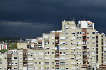 Stormy dark blue sky above a quarter of tall residential buildings