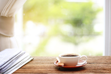 Morning coffee, Cup of coffee with newspapers, near the window.background in the morning sunlight.