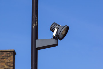 CCTV security camera and surveillance on a pole against the backdrop of blue sky