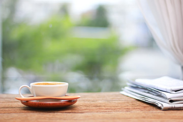 Morning coffee, Cup of coffee with newspapers, near the window.background in the morning sunlight.