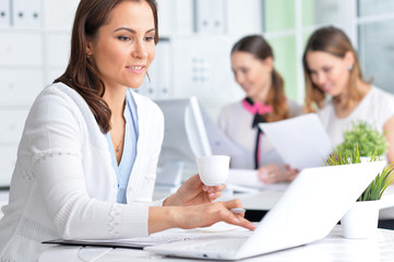 Obraz premium Portrait of a happy business woman using laptop 