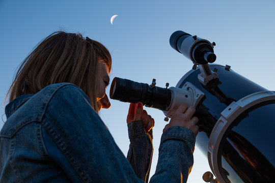 Girl looking at the Moon through a telescope. My astronomy work.