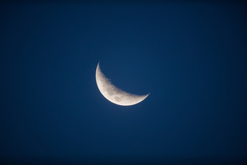 Obraz na płótnie Canvas Half Moon on a dark - blue background. Photographed through a long focal telescope. 