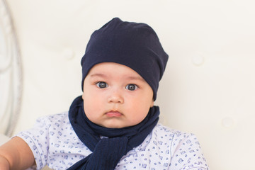 Close up portrait of cute baby boy wearing blue hat.