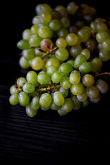 Beautiful fresh bunch of grapes on a dark wooden background. The droplets of water.Healthy eating
