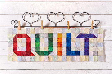 The word quilt sewn from colorful square and triangle pieces of fabric