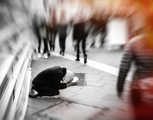 People passing indifferently next to beggar black and white image