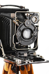 Old camera on a tripod on a white background