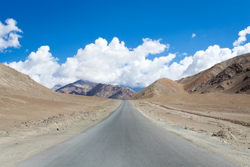 Fototapeta na wymiar The road cuts through the rocky mountainside Magnetic Hill Road, Leh Ladakh India