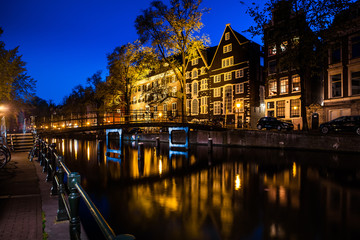 Night shot of Amsterdam canal city view with bicycles on the bridge, Netherlands