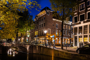 Fototapeta premium Night shot of Amsterdam canal city view with bicycles on the bridge, Netherlands