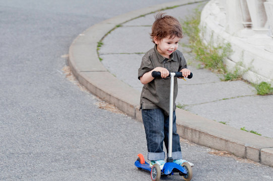 Cute Little Boy Riding Push Scooter