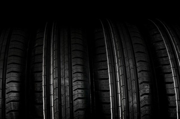Obraz premium Car tires in row isolated on black
