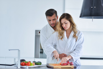 Happy couple cooking breakfast together in the kitchen