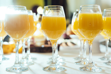 Glasses with tasty fresh orange fruit juice on summer wedding greeting