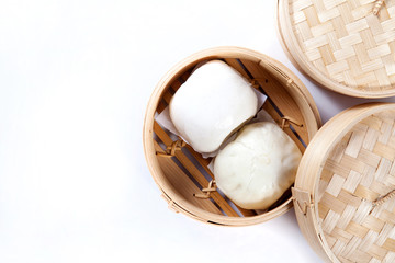 Steamed buns in bamboo steamer on white background, chinese dim sum