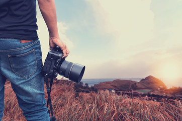 Close-up shot of man  holding camera  standing on the hill