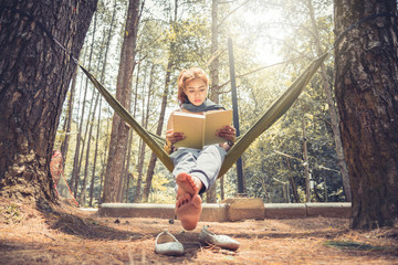 Women sitting reading. In the hammock. In the natural atmosphere in the park