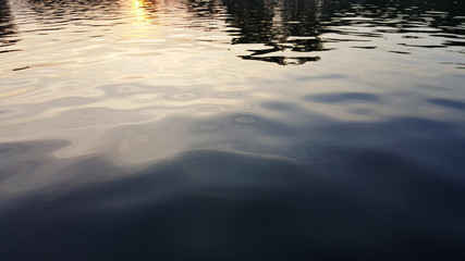 Water surface with ripples and sunlight reflections