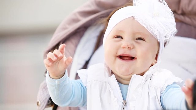 closeup smiling baby girl sitting in the stroller