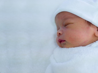 newborn baby sleeping on blanket.  in a hospital.