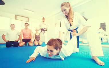 Young women in sparring work out painful techniques