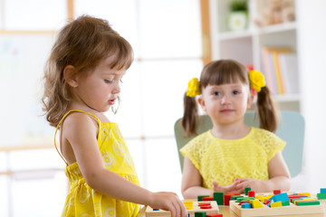 children learning to sort shapes in kindergarten or daycare center