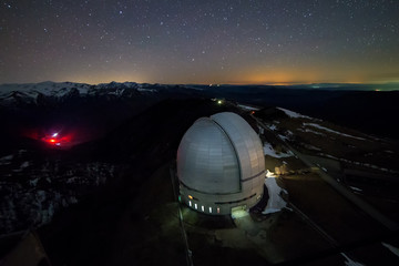 Fototapeta na wymiar Night view from above to the large dome of the telescope of the special astrophysical observatory in the Arkhyz mountains