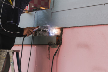 Workers make sparks from welded steel to add a home.