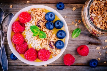 Peach smoothie bowl with raspberries, blueberries, granola and coconut